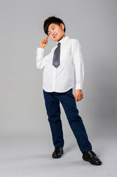 Portrait of handsome asian schoolboy in formal uniform in studio