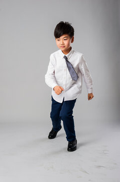 Portrait of handsome asian schoolboy in formal uniform in studio