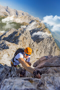 Via Ferrata Climber Ascending a Rocky Wall in the Alps