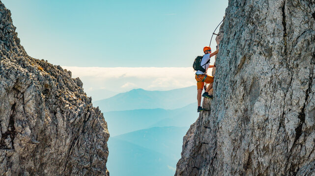 Via Ferrata Climber Ascending a Rocky Wall in the Alps