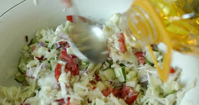 Close-up male hands prepare salad stirring with oil and salt. 4K 10-bit