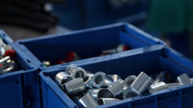 Hydraulic fittings blue bins closeup. Camera pan metal ferrules factory parts.