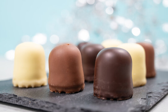 Chocolate teacakes, coated marshmallow treats, krembo, pastry sweets with cookies, fluffy cream and glaze, traditional winter dessert, food selection
