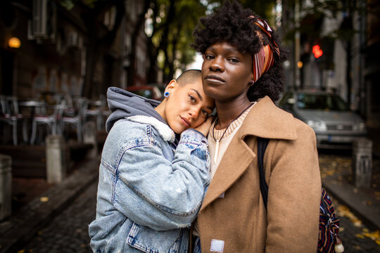 Friends embracing on a city street in autumn