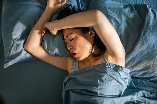 Woman sleeping in bed with mouth open
