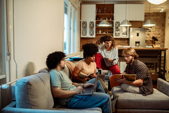 Study group collaborating with laptop at home