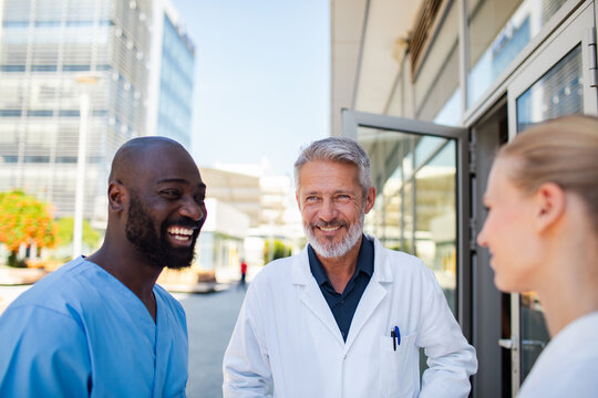 Doctors and nurse talking outside hospital entrance