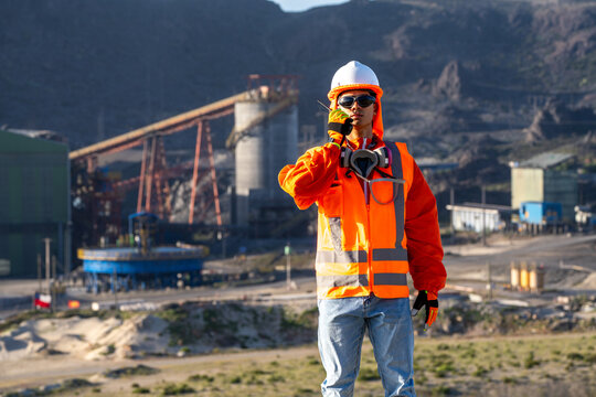 Mine worker in protective gear communicating by radio at an open-pit mining operation
