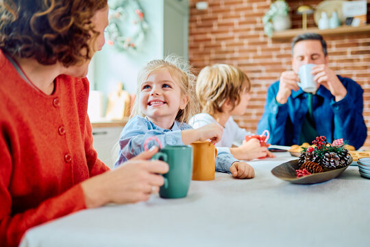 Family members enjoying breakfast around the kitchen table, sharing drinks and smiles during a relaxed morning at home