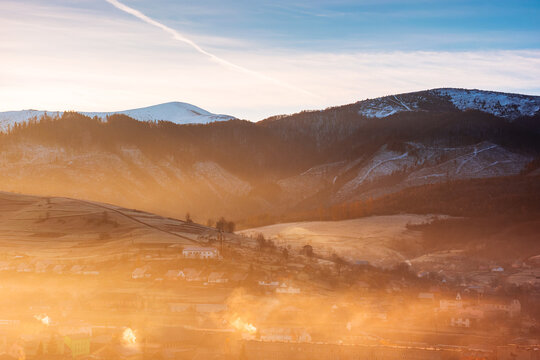 mountainous countryside landscape at sunrise. dramatic light and glowing fog in the distant valley. fields and trees on the hill. beautiful rural scenery of Carpathians