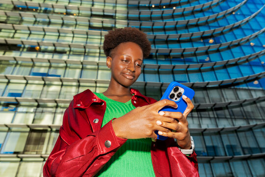 Young Black Gen-Z woman using smartphone with motion blur