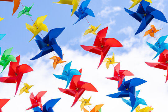 Colorful pinwheels floating against blue sky for festival decor