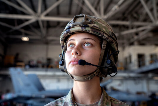 Female soldier with headset beside military drone aircraft