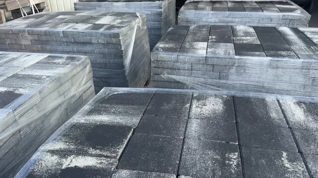 Pallets of dark grey concretePallets of dark grey concrete paving slabs wrapped in plastic film in storage paving slabs in outdoor storage. High quality 4k footage