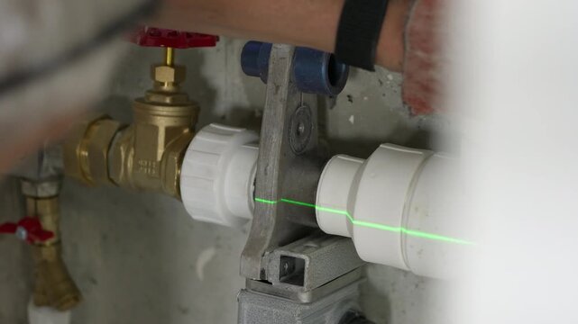 Plumber heating polypropylene water pipes with welding iron for joining