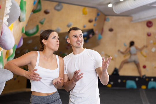Athletic young man and young woman talking near climbing wall