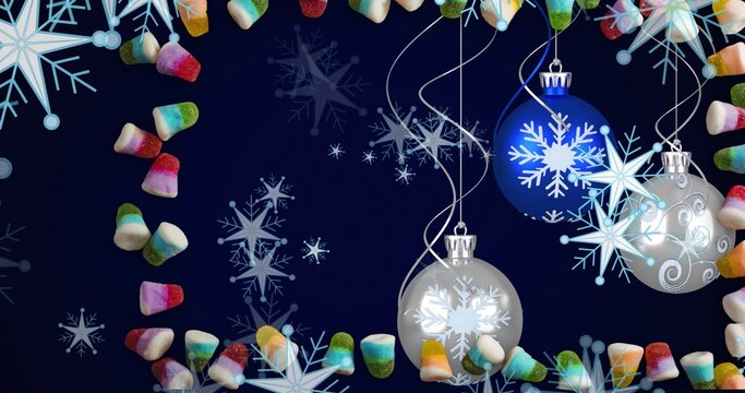 Swinging cluster of three baubles glinting on navy backdrop with snowflakes, candy frame