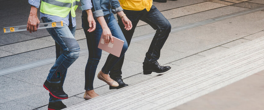 Banner Team engineer walking on stair in modern city together. Close up legs of team walk on street. Banner asian team step up, step down outside. Close up legs woman man walking city stair