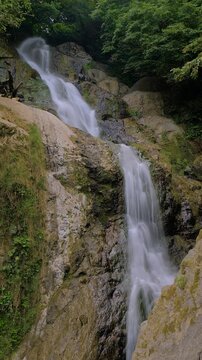 Timelapse: Andrew the Apostle waterfall in the mountain - river or stream of water is flowing and falling down: vertical video. Environment, nature, time lapse, long exposure and landscape concept