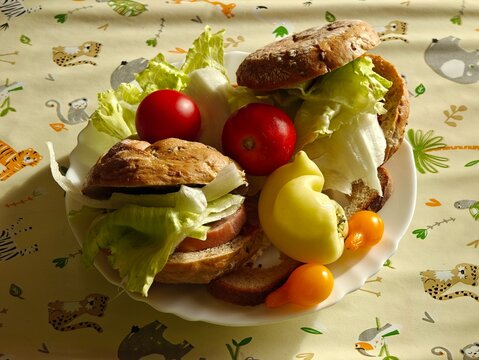 Homemade filled roll served with a plate of bell peppers and tomatoes.
