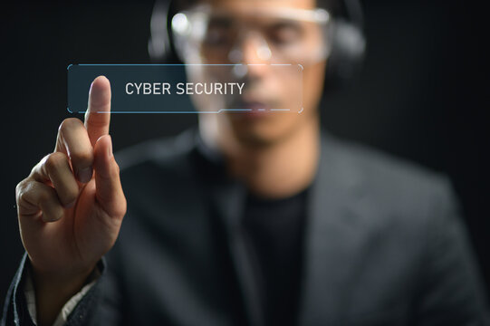 Modern male professional engaging with digital cybersecurity interface in a dark environment