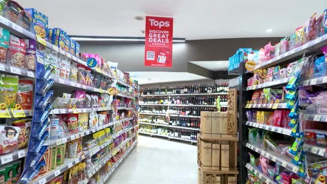 Camera Movement Through Supermarket Aisle with Shelves of Snacks and Wine