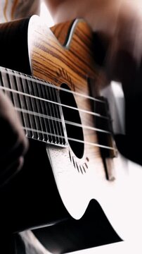 Musician strumming wooden ukulele strings close up