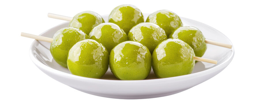 A white plate holds several matcha dango on wooden sticks, evenly coated and ready to enjoy.