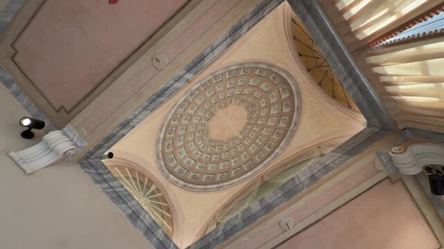 An upward view rotates across a painted coffered dome, faux-marble borders and ornamental ceiling panels.