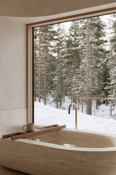 Travertine soaking tub with wooden tray and mug beside window overlooking snowy pine forest japandi bathroom