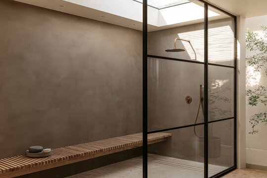 Japandi bathroom with glass shower partition, oak slatted bench, skylight, and muted plaster walls