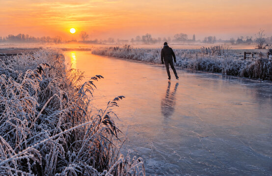 Solitary Skater Gliding Across Natural Ice in the Dutch Countryside