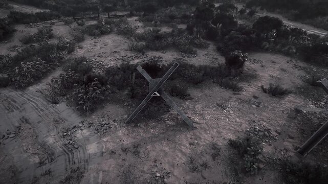 High angle view showing an anti tank metal hedgehog barrier placed on bare earth with scattered vegetation and tire tracks in a desolate outdoor area