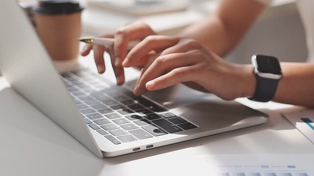 Closeup of the hands of a receptionist typing and sending emails while working in an office alone. One secretary doing admin and writing reports while organizing a schedule for her manager at work