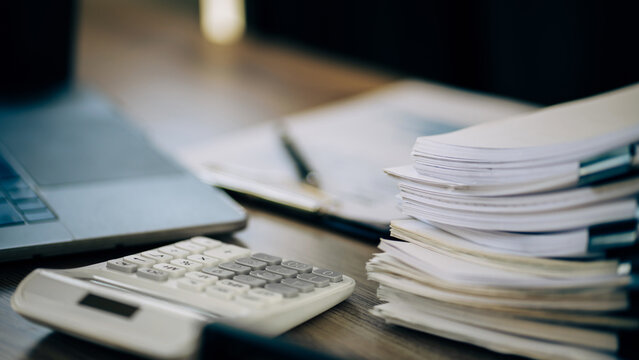 Stacks of file spreadsheets at office desk, overload work