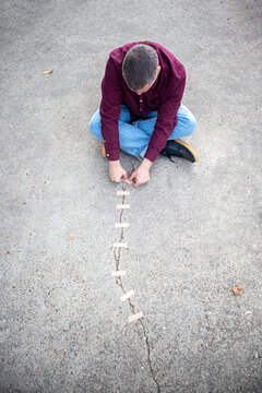 Man outdoors repairing cracked concrete with bandages for healing