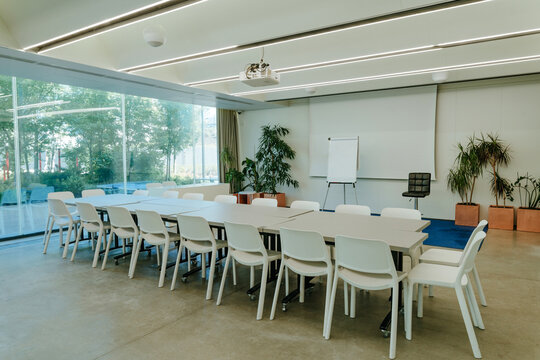 An empty modern conference room features a large table and chairs