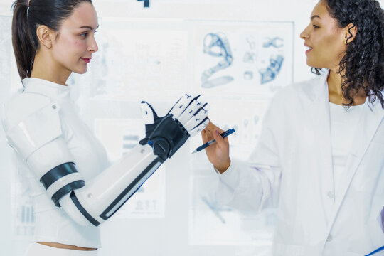 Sensor driven robotics research: the reviewer reaches out with her pen toward the raised robotic fingers, marking where the tactile pads are to be repositioned next