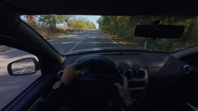 Driving car POV interior view of hands on steering wheel along highway