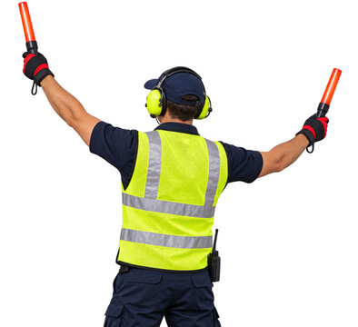 Airport ground crew worker holding illuminated marshalling wands