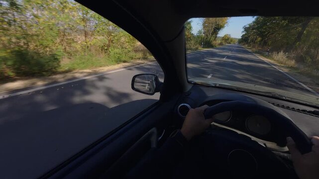 Driving car POV interior view of hands on steering wheel along highway