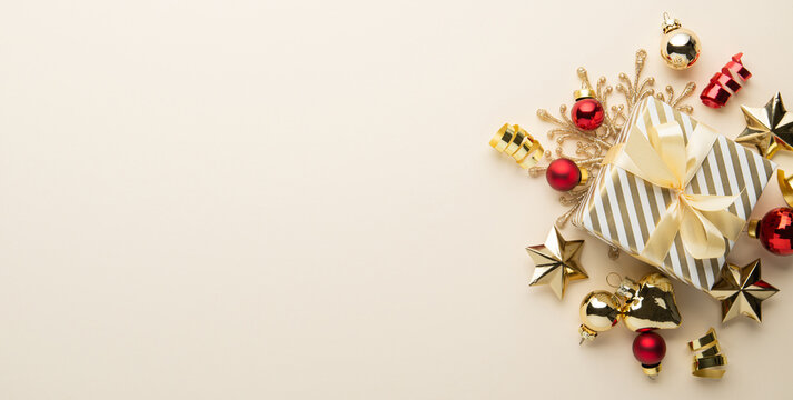 Beige Christmas and Happy New Year holiday background with gift boxes, golden ribbon bows and festive golden and red ornaments, flat lay with copy space. Greeting card.