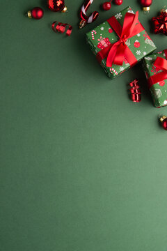 Merry Christmas and Happy Holidays greeting card, frame, banner. New Year. Red Christmas ornaments and gifts, presents on green background top view. Xmas holiday festive theme. Christmas decoration