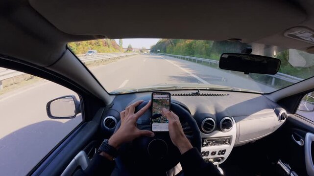 Driver Using Smartphone Map While Driving on Highway, POV in Autumn