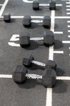 Dumbbells on a marked gym floor for strength training