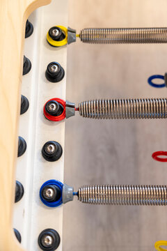 Pilates reformer springs and color-coded resistance settings in fitness studio