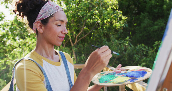 woman painting on canvas in the balcony at home