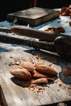 rusty hammer and almonds on a worn wooden block