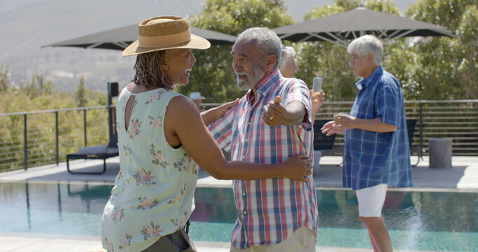 Happy african american senior couple hugging at swimming pool