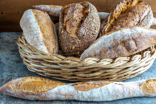 Crusty assorted bread loaves in wicker basket display